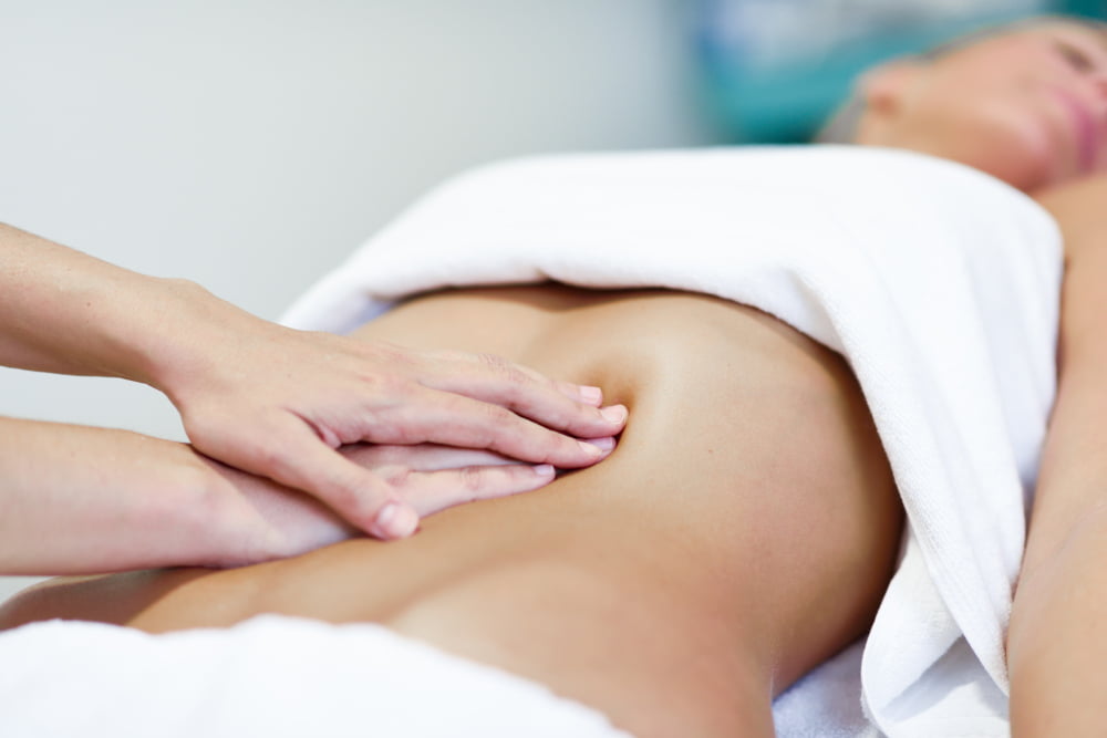 hands massaging female abdomen therapist applying pressure belly